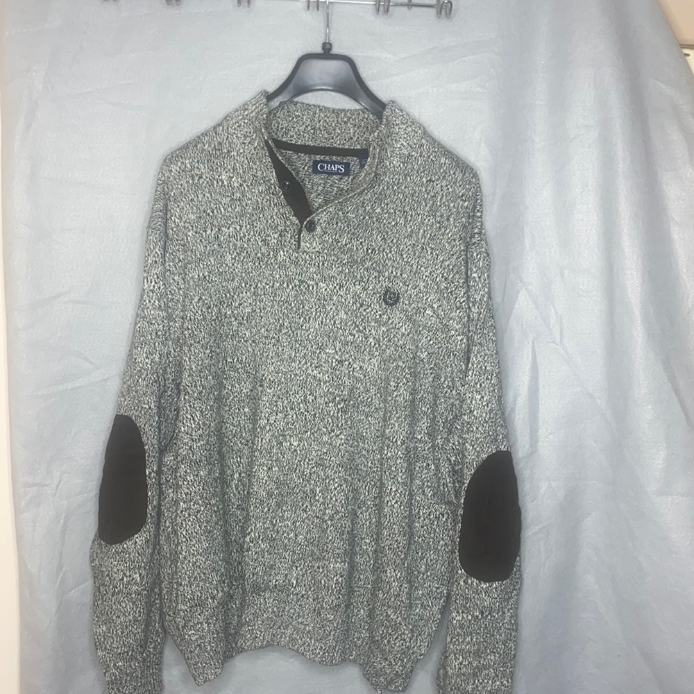 Black and white pullover sweater with 3 buttons.